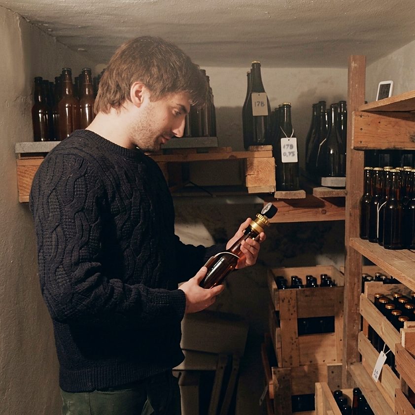 Tommaso tra le bottiglie nella prima cantina di fermentazione